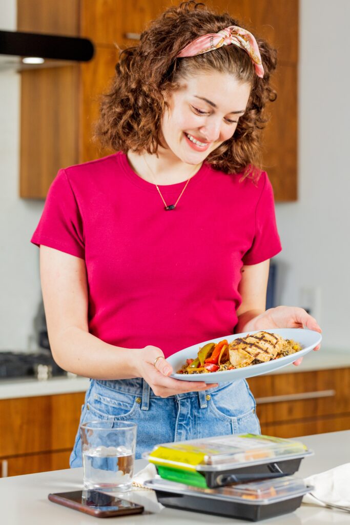 Happy customer unboxing a prepared healthy meal delivery from ProMeals